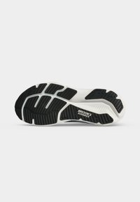 Semelle de chaussure de course Brooks Glycerin 6TS noire et blanche avec des motifs de semelle pour la traction sur un fond clair uni.