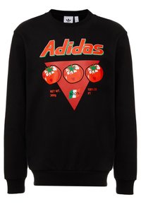 Black sweatshirt with red "Adidas" text above three red tomatoes on a red triangle, with small text and a green, white, and red flag graphic.