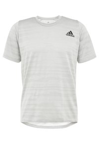 Camiseta deportiva gris claro de manga corta con un sutil patrón de rayas, escote redondo y logo negro de Adidas en el pecho izquierdo.