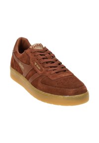 Braune Wildledersneaker mit Gummisohle, mit Schnürdesign, durchlöchtem Zehenbereich und goldenen Logo-Akzenten an der Seite und auf der Zunge.