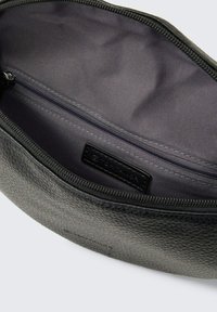 Bolsita de cuero negro texturizado con interior de tela gris, que cuenta con un cierre de cremallera en la parte superior y una pequeña etiqueta de la marca en el interior.