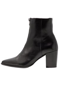 Botín de cuero negro hasta el tobillo con punta afilada, cierre lateral y tacón grueso de altura media.