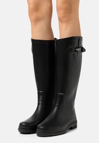 Black rubber rain boots with a smooth finish, knee-high design, adjustable buckle accents on the top, and textured soles for grip.