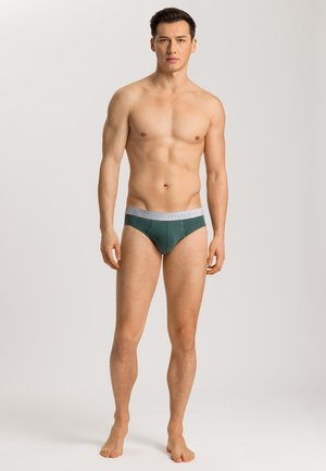 Couverture en sous-vêtements pour hommes de couleur verte avec une ceinture grise portant le nom de la marque. Tissu doux avec un ajustement serré et sans motifs visibles.