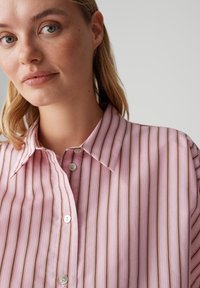 Koszula na guziki w różowych odcieniach z brązowymi paskami, z klasycznym kołnierzem i lekką, gładką fakturą materiału.