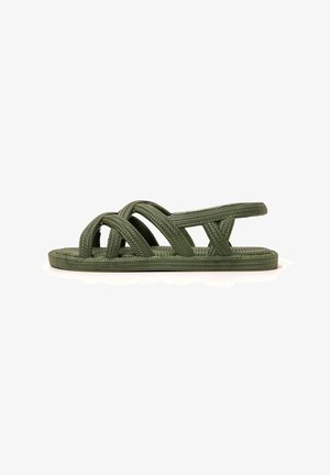 Green woven flat sandals featuring crisscross straps and a textured footbed, designed for comfort and breathability.