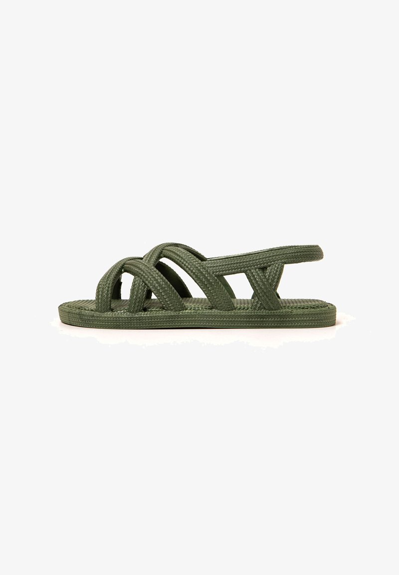 Grüne geflochtene flache Sandalen mit übereinanderliegenden Riemen und einer strukturierten Fußbett, entworfen für Komfort und Atmungsaktivität.