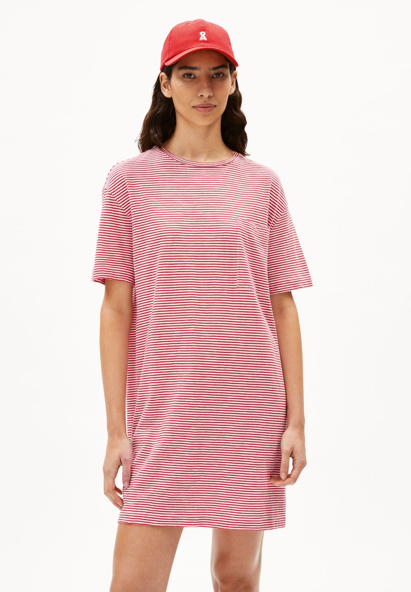 Rode en witte gestreepte t-shirt jurk met korte mouwen, ronde halslijn en een borstzak aan de linkerzijde. Gecombineerd met een effen rode pet.