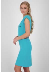 Turkusowa sukienka z krótkim rękawem o luźnym kroju, zebrana w talii brązowym paskiem. Gładki materiał i prosty fason, długość do kolan.