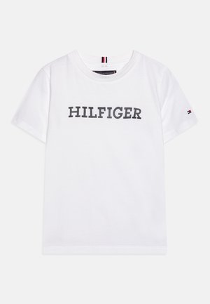 Biała koszulka z krótkim rękawem z napisem „HILFIGER” na środku z przodu oraz małym logo Tommy Hilfiger na lewym rękawie.