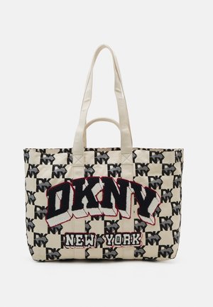Beżowa torba typu tote z czarno-białym wzorem DKNY NY, dużymi literami DKNY oraz mniejszym napisem New York, wyposażona w dwa długie i jeden krótki uchwyt.