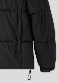 Czarna puchowa kurtka z pikowaną fakturą, z zamykaną na zamek kieszenią oraz regulowanymi ściągaczami przy mankietach, pozwalającymi na dopasowanie do indywidualnych potrzeb.