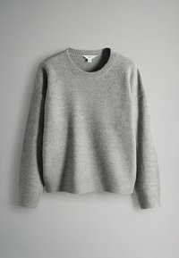 Szary sweter dzianinowy z okrągłym dekoltem, ściągaczami na mankietach i na dole, miękką fakturą oraz luźnym krojem, prezentowany na neutralnym tle.