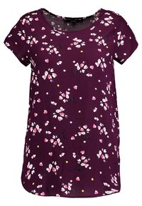 Fioletowa bluzka z krótkim rękawem w różowy i biały wzór kwiatowy, z małymi żółtymi akcentami, z okrągłym dekoltem.