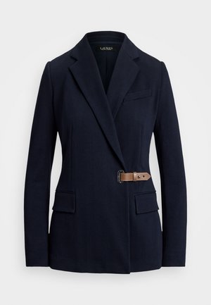 Blazer blu navy con rever a punta, due tasche frontali a patta, tasca welt sul petto e un dettaglio con fibbia in pelle marrone sul lato destro.