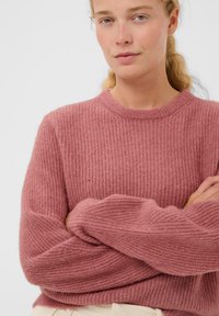 Strikket sweater i blød pink med ribbestruktur, rund udskæring og forlængede ærmer, med en afslappet pasform.