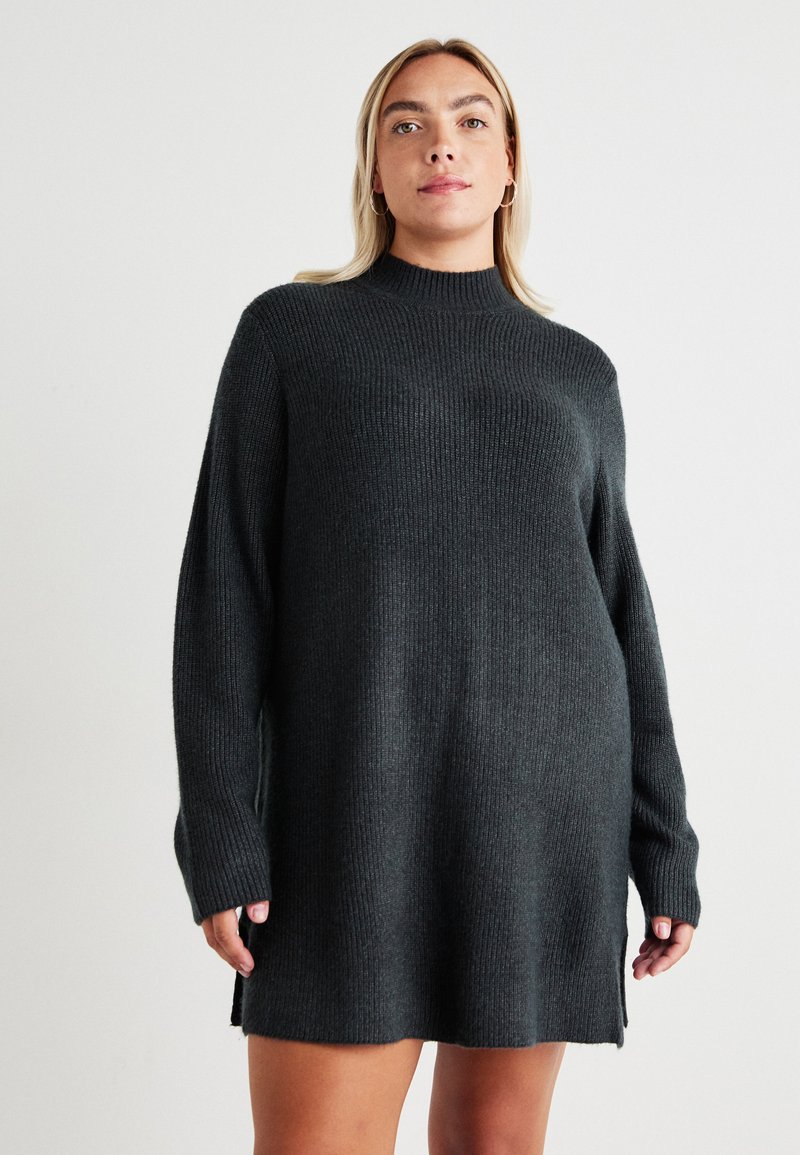 Dark gray knitted dress with a high neck, long sleeves, ribbed texture, and side slits at the hem for added ease and movement.