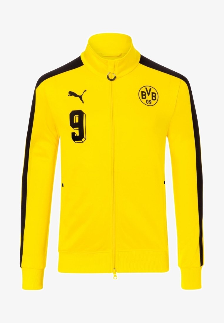 Chaqueta amarilla con cremallera, cuello alto, paneles laterales negros y acentos negros. Presenta el "9" y el logo del Borussia Dortmund en el pecho.