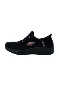 Black athletic shoes with a textured surface, featuring a cushioned sole and a subtle logo. Lace-up design with contrasting accents.