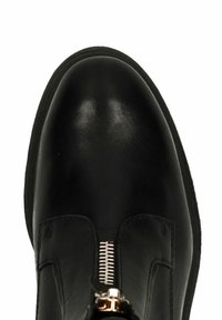 Zwarte leren enkellaars met een afgeronde neus, ritssluiting met goudkleurig beslag en een gladde textuur. Geen zichtbare patronen.