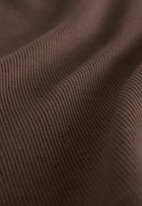 Tkanina w ciemnobrązowym kolorze o pionowej, prążkowanej fakturze, ukazująca miękką, gładką powierzchnię oraz subtelne różnice odcieni i głębi.