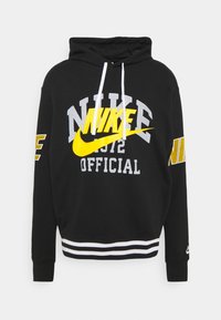 Svart hoodie med vita dragskor, med gula och grå Nike-grafiker, randig nederkant och logotypdetaljer på ärmarna.