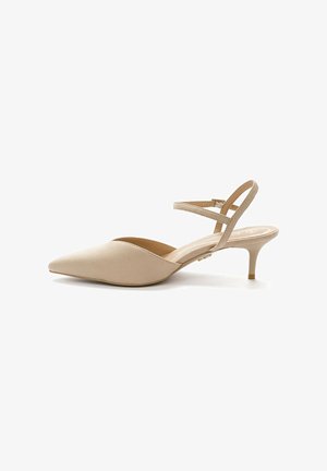 Beige slingback pumps with a pointed toe, low kitten heel, and soft suede texture. Features a crisscross strap design.