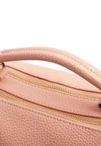 Borsa a tracolla in pelle con texture a pesca, dettagli in metallo dorato e manico curvo. Presenta una finitura liscia e un design strutturato.