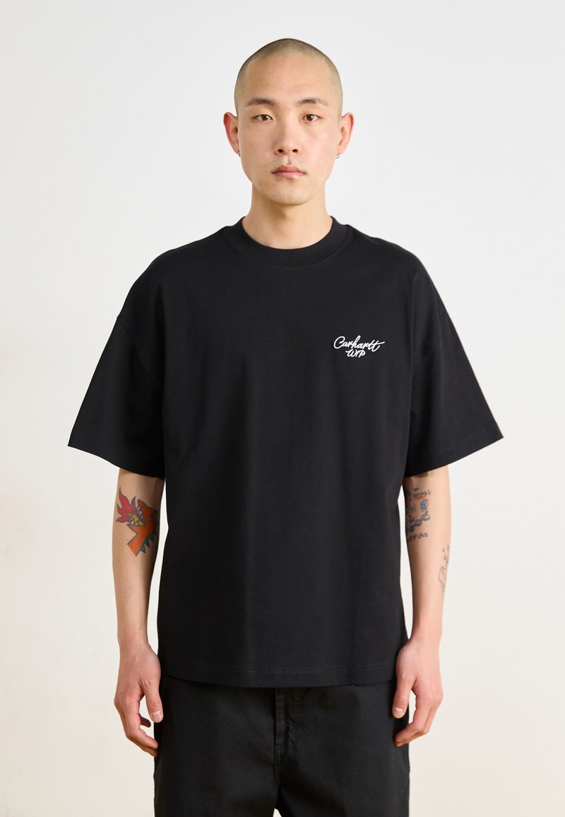 Crna pamučna majica kratkih rukava, okrugli izrez i bijeli vezeni "Carhartt" logo na lijevoj strani prsnog koša. Jednostavan, ležeran kroj.