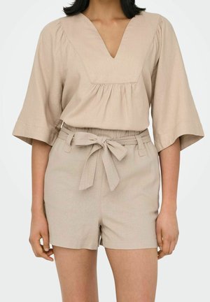 Beige linnen top met een V-hals en korte mouwen, gecombineerd met bijpassende, hooggetailleerde shorts met een strikceintuur.