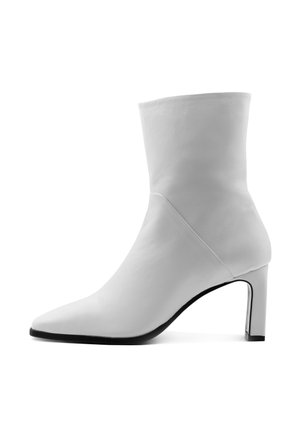 Bílé kožené kotníkové boty s špičatou špičkou, vysokým blokovým podpatkem a hladkým povrchem; mají elegantní design s minimálním zdobením.