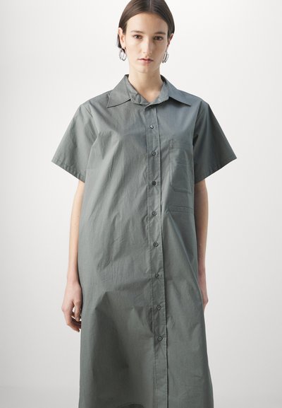 Rochie cămașă în nuanțe de gri moale, cu mâneci scurte, guler clasic, buzunar pe piept și o croială lejeră.
