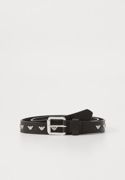 Ceinture en cuir noir avec des ferrures en argent et des accents de logo en relief décoratifs le long de la sangle. Texture lisse et plate avec une boucle classique.