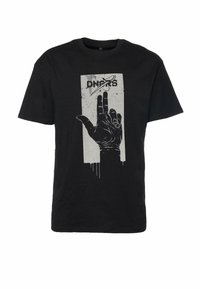 Sort bomulds t-shirt med et sølvfarvet grafisk motiv af en hånd med løftede fingre. Designet inkluderer en rektangulær ramme og tekst.