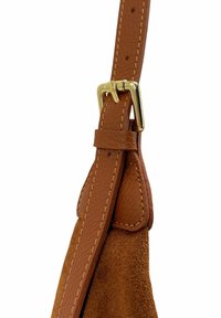 Sangle en cuir tan avec une boucle en or, présentant des détails texturés et des coutures contrastantes, attachée à une section en daim brun doux.
