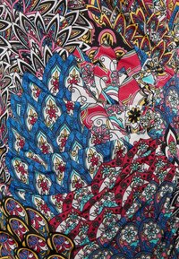 Kleurrijke gelaagd stof met ingewikkelde bloem- en paisleypatronen in blauw, rood, geel, zwart en wit, die een textuurvol, elkaar overlappend ontwerp vormen.