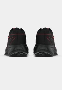 Μαύρα αθλητικά παπούτσια με υφή στην επάνω πλευρά, αντίθετες κόκκινες ραφές και καμπύλη μαύρη σόλα με σχέδιο πέλματος.