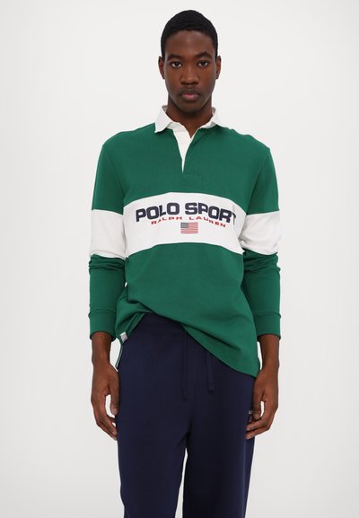 Grön och vit långärmad polo med krage, med ett horisontellt "POLO SPORT"-logotyp och marinblåa sweatpants.