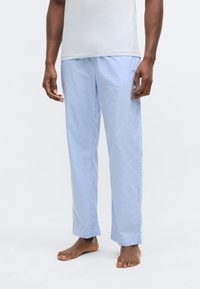 Sinivalkoruudulliset pyjamanhousut, valmistettu kevyestä kankaasta, joustavalla vyötärönauhalla ja rennolla istuvuudella. Yksittäinen kirjailtu logodetaili.