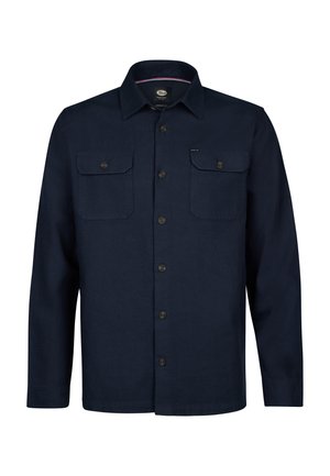 Laivastonsininen napillinen paita, jossa pitkät hihat, kaksi rintataskua ja suora leikkaus. Valmistettu teksturoidusta kankaasta, jossa näkyvät ompelusaumat.