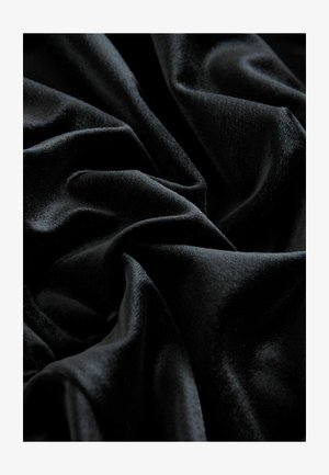 Schwarzer Samtstoff mit einer glatten, luxuriösen Textur, der sanfte Falten und Lichtreflexionen zeigt und die reichhaltige Farbe und den Glanz betont.