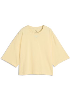 T-shirt oversize jaune clair à manches courtes, encolure ronde et petits logos bleus Puma et Nyerox sur la poitrine.