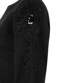 Czarny sweter z dzianiny ozdobiony dekoracyjnym wzorem kwiatowym z czarnych cekinów i nitkowym zdobieniem na rękawie.