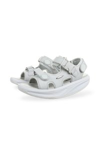 Sandalias blancas con correas ajustables, recortes y una suela gruesa. Fabricadas en material sintético, con acentos circulares y una textura suave.