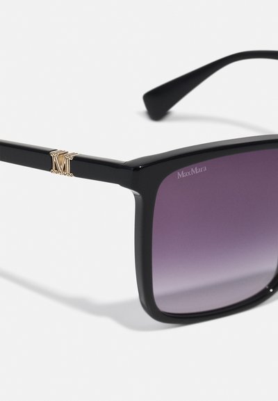 Óculos de sol quadrados pretos com lentes roxas em degradê. Possui um detalhe em logo dourado na armação, perto das hastes. Acabamento brilhante, design robusto.