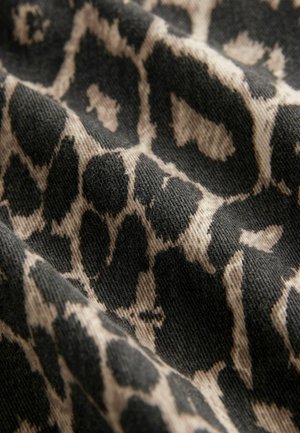 Čierna a béžová tkanina s leopardím vzorom, s textúrovanými, tkanými vláknami a rôznymi tvarmi miest po celej ploche.