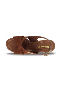Sandale compensée en suède marron avec des brides croisées et une boucle à la cheville. Semelle intérieure texturée avec le logo doré "Les Tropeziennes".