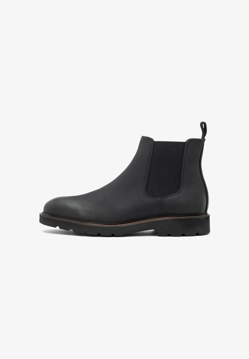Stivale Chelsea in pelle nera con pannelli elastici laterali, punta tonda, suola strutturata e passante sul retro per una facile calzata.