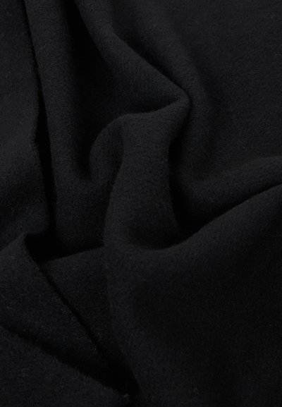Tissu noir doux avec une texture légèrement duveteuse, délicatement plié pour montrer son épaisseur et sa chaleur.