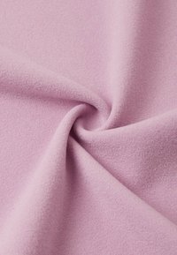 Tessuto rosa chiaro con una texture liscia, caratterizzato da una trama sottile e uniforme. Il materiale è leggero e cade delicatamente, evidenziando pieghe morbide.